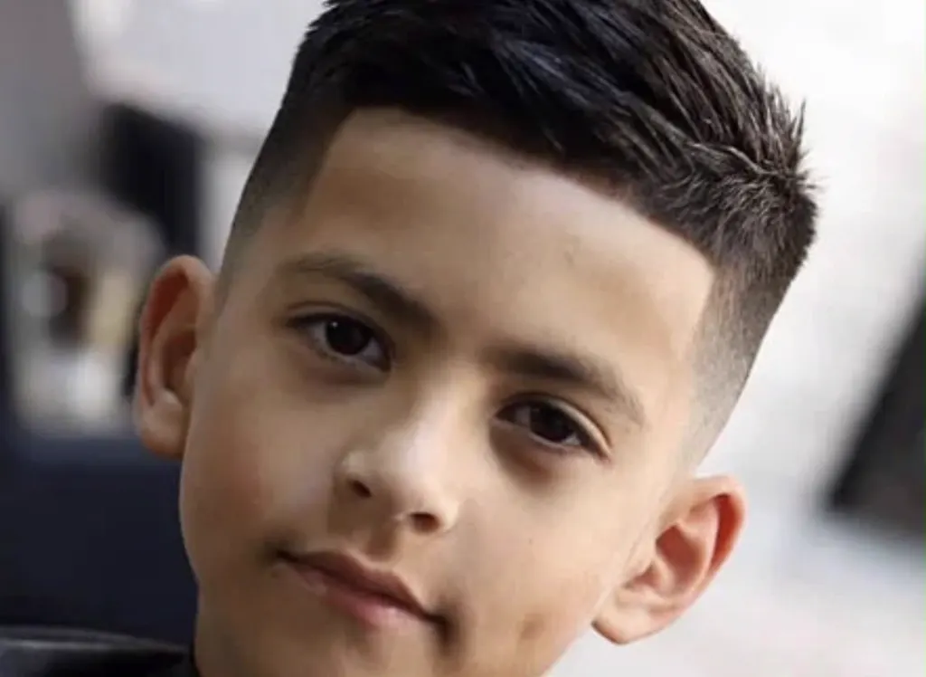 Young boy with a sharp, clean fade haircut from Atlas Barbershop